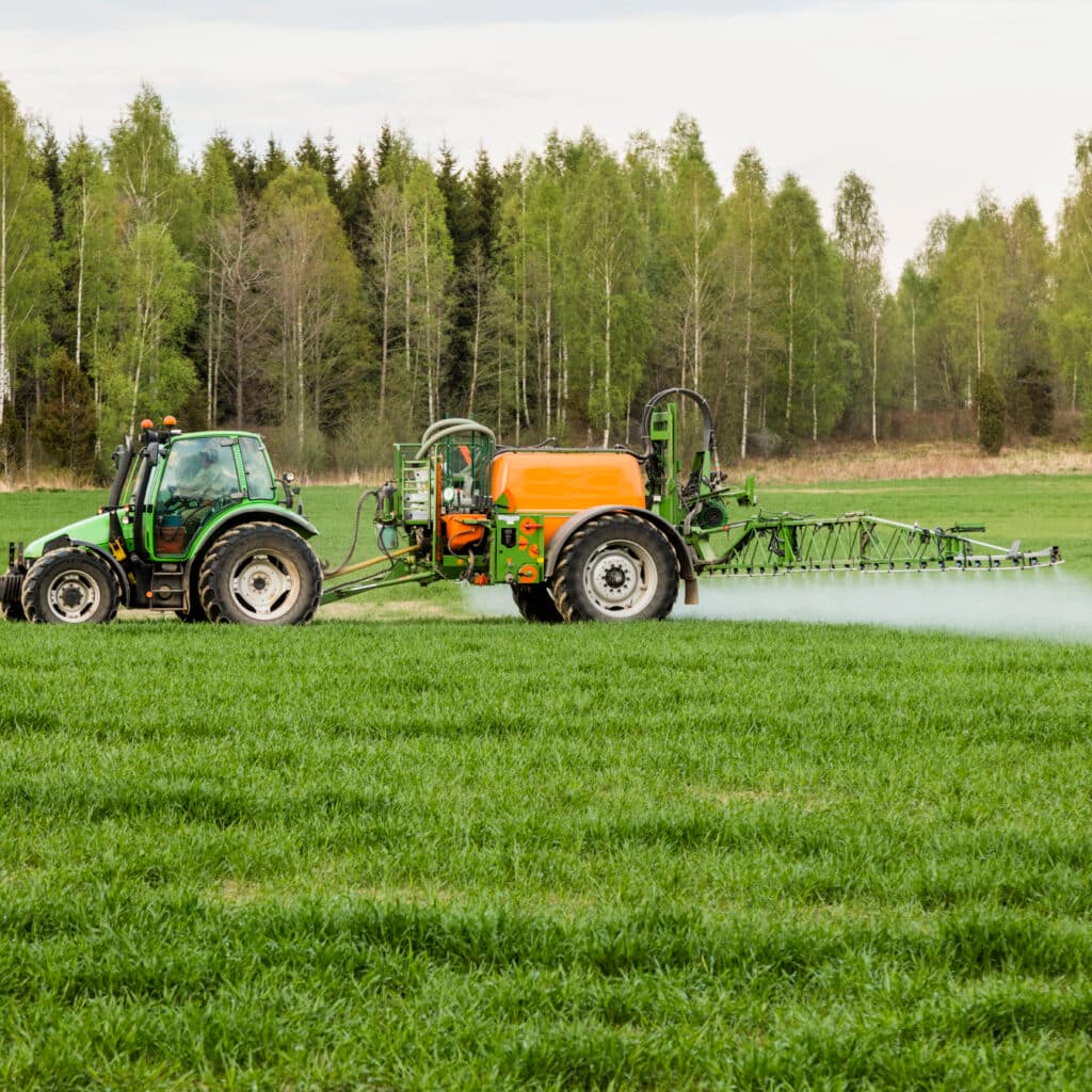 En traktor besprutar ett fält med bekämpningsmedel med PFAS någonstans i Sverige